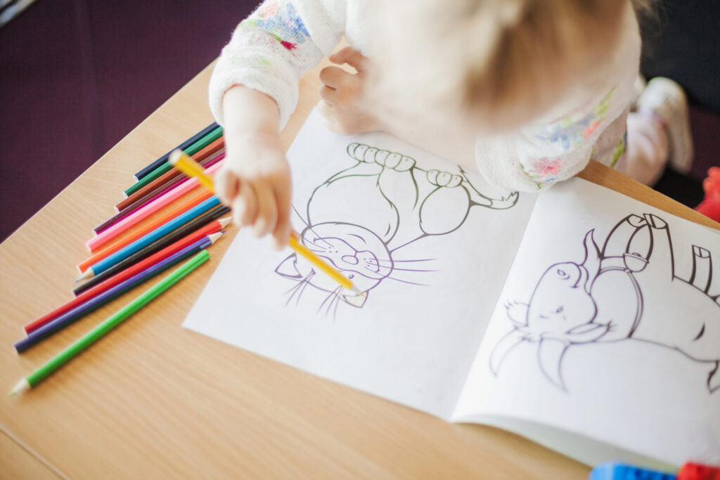 girl holding pencil sitting table